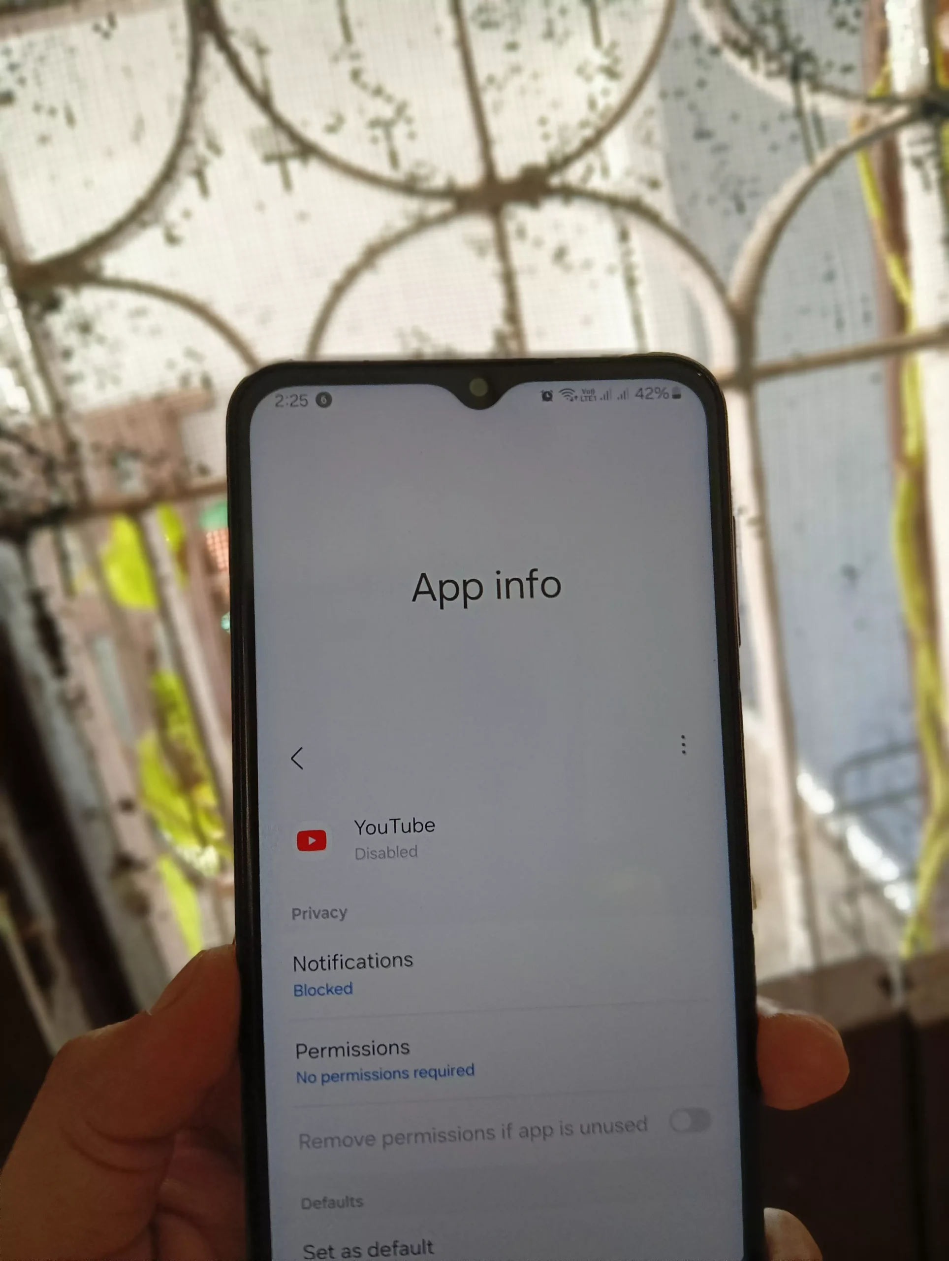 image of phone in hands with youtube app info and it is disabled